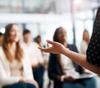 Decorative image (A person addresses a group in a room)