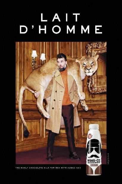 Une publicité pour le lait au chocolat 'Lait D'Homme' montrant un homme en manteau de fourrure portant un lion sur ses épaules.