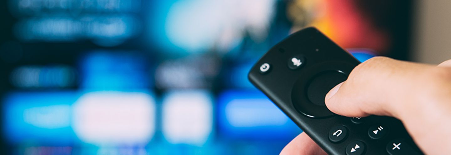 Hand holding a TV remote control