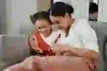 Woman and child looking at a cell phone and smiling 